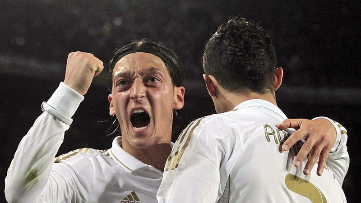 Cristiano Ronaldo, de espaldas, celebra su gol, segundo de su equipo, junto a su compañero alemán Mesut Özil, que lo festeja con mucha rabia.