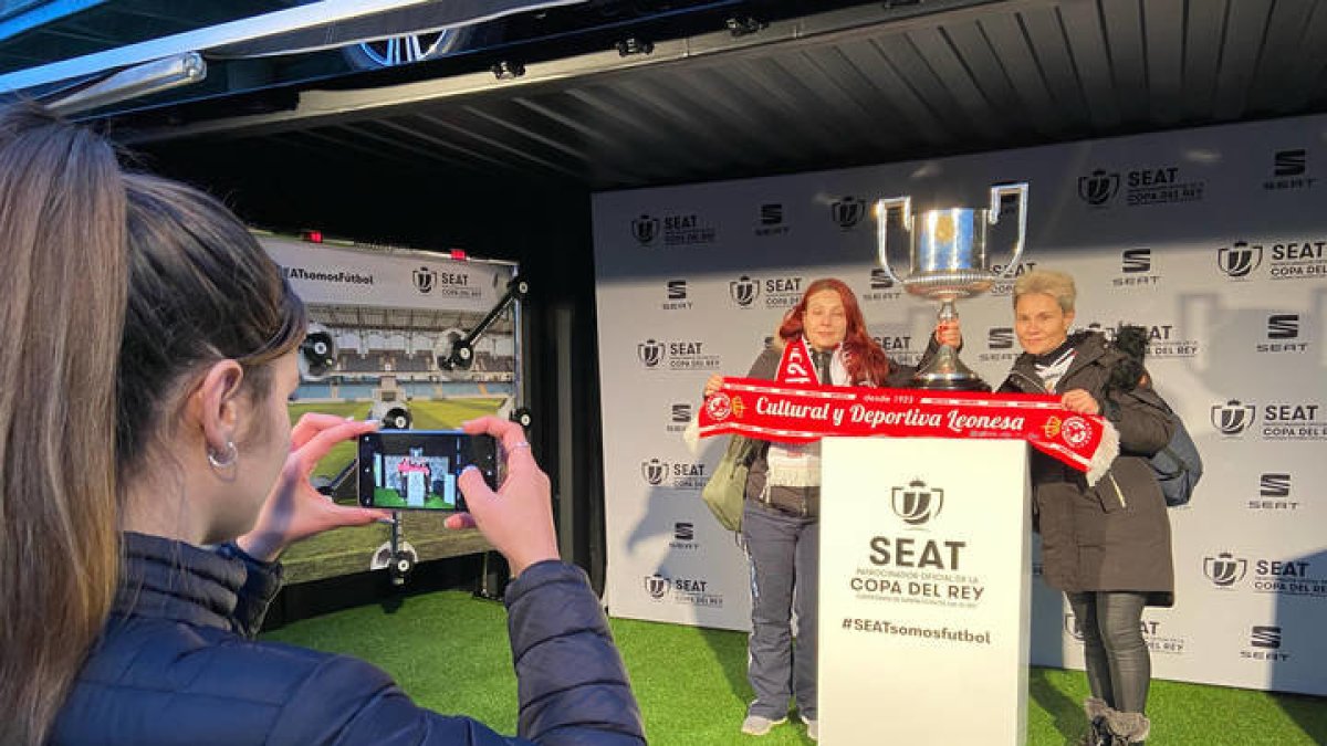 Los aficionados se fotografían ante la Copa del Rey en León. RAMIRO