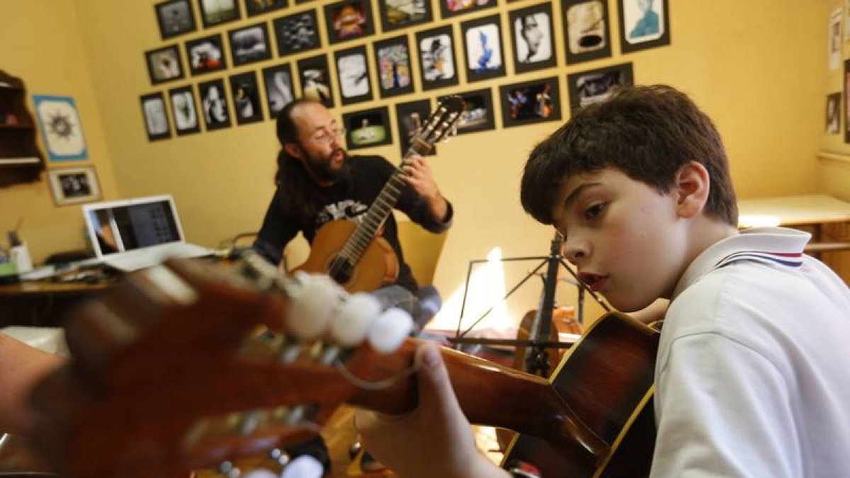 El profesor Israel Quintana en una clase de guitarra con un alumno