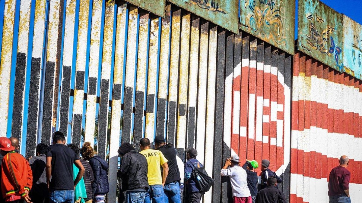 Migrantes de la primera caravana que salio desde honduras y recorrio el territorio mexicano comienzan a congregarse en la valla fronteriza de Tijuana Mexico.