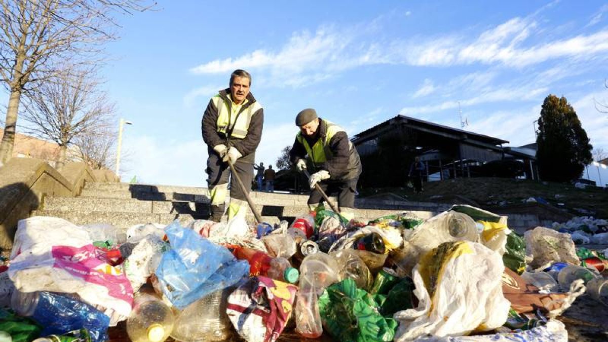 Operarios de las brigadas de limpieza recogiendo los restos del botellón