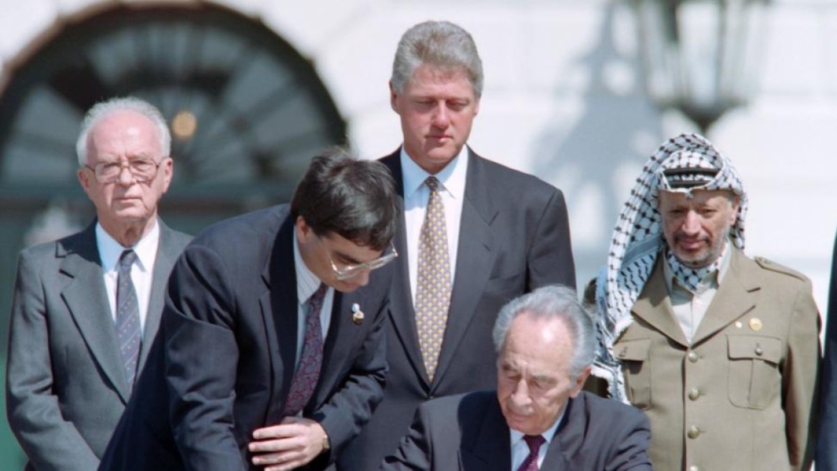 Peres firma los acuerdos de Oslo, observador, de izquierda a derecha, por Isaac Rabin, Bill Clinton y Yasir Arafat, el 13 de septiembre de 1993.