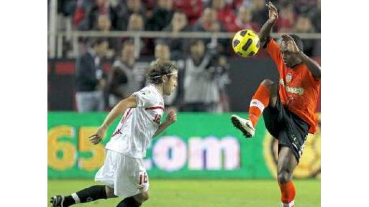 El defensa portugués del Valencia Miguel Brito, derecha, lucha un balón con Diego Capel.