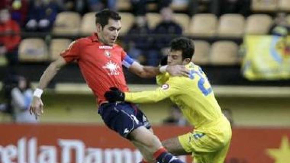 Rossi (d) y el defensa de Osasuna Miguel Flaño luchan por un balón