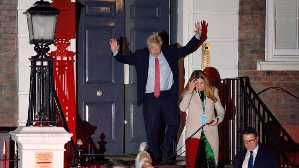 Boris Johnson celebra su aplastante victoria y sale ayer por la noche del 10 de Down Street con su novia Carrie Symonds y su perro. NEIL HALL