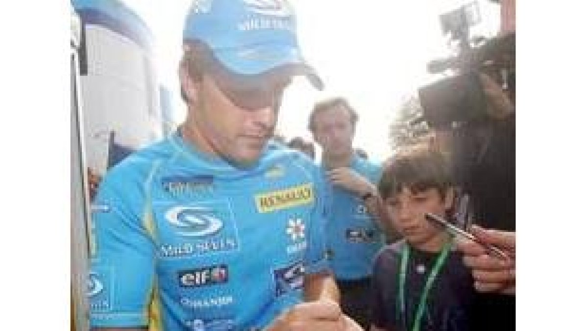 Fernando Alonso, firmando autógrafos, se muestra confiado en Monza