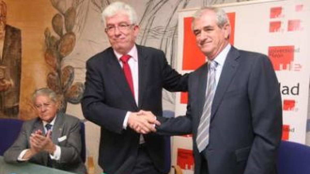 Hermida y Guisasola se estrechan las manos, en presencia de Urbano González.