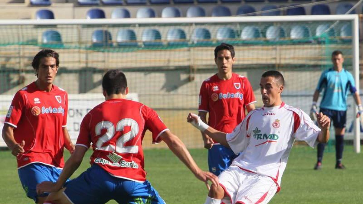 Tres jugadores del Numancia intentan frenar el avance del centrocampista Mario Villar.