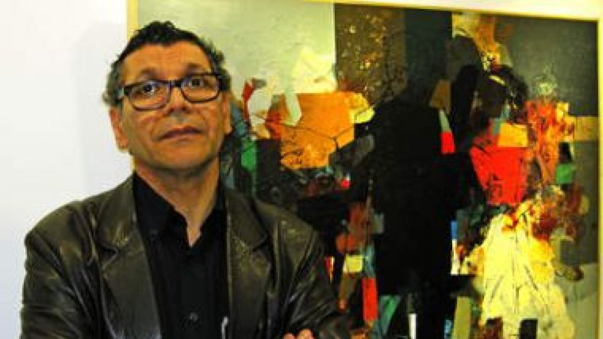 El artista iraquí Hanoos ante una de las obras de la exposición.