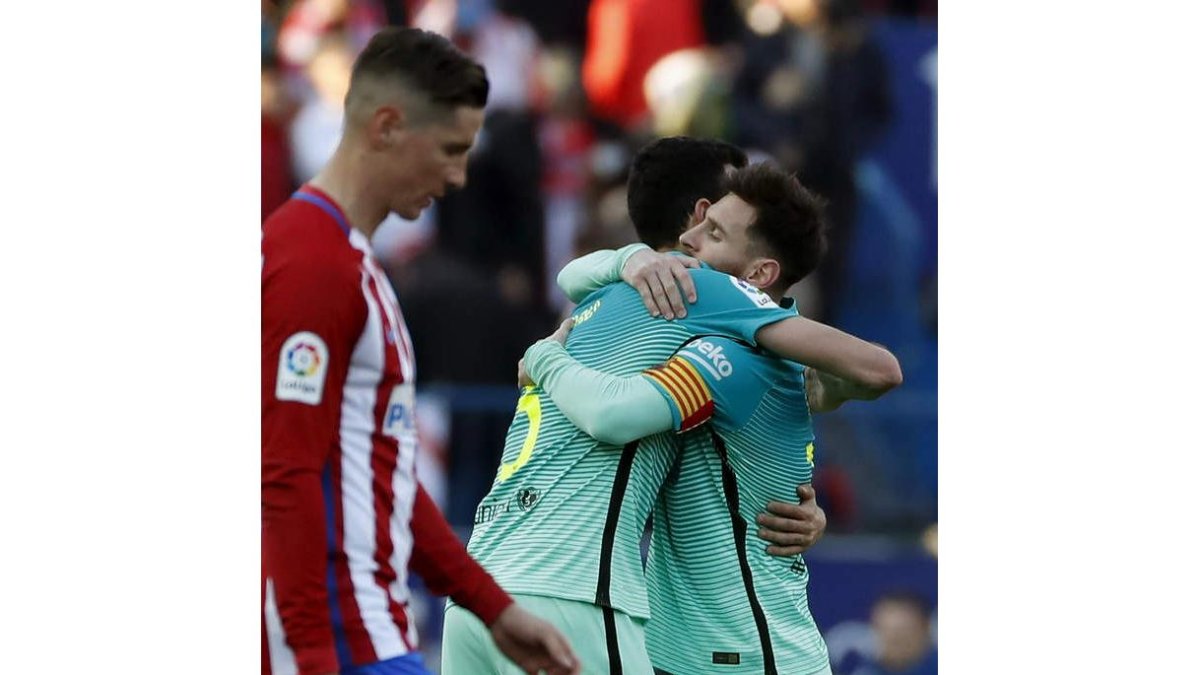 Busquets y Messi celebran el gol de la victoria ante un Fernando Torres cariacontecido. JAVIER LIZÓN