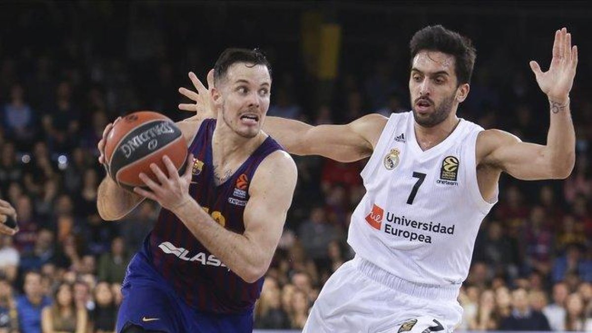 El base azulgrana Heurtel conduce el balón presionado por el madridista Campazzo.