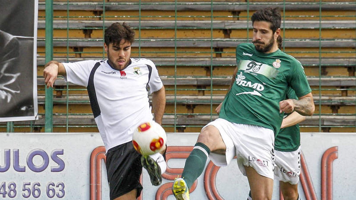 Dani Hedrera, a la derecha, disputa un balón con el delantero del Burgos CF Prats en un lance del encuentro en El Plantío.