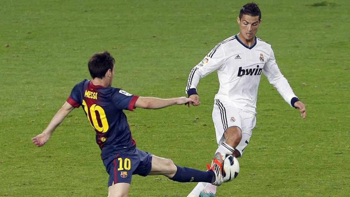 Messi y Cristiano luchan por el balón durante un Barcelona-Real Madrid.