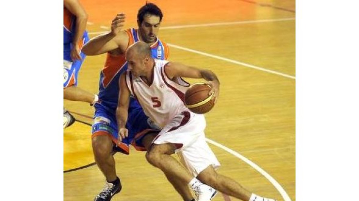 Juanjo Bernabé trata de zafarse de un contrario antes de marcar jugada.