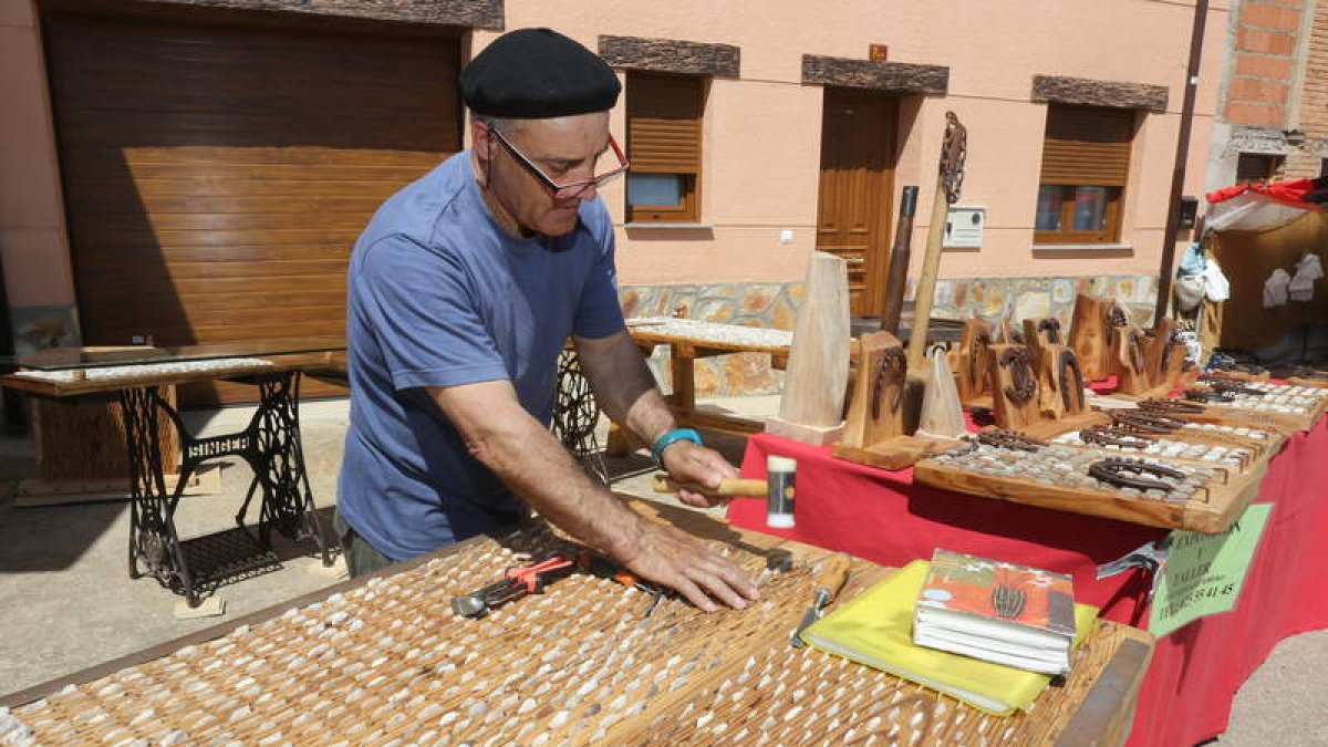 Un artesano aprovecha un instante para empedrar uno de los trillos que ofrece al público.