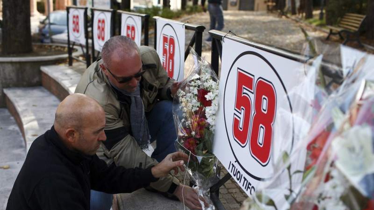 Aficionados dejan flores ante un cartel con el dorsal de Simoncelli.