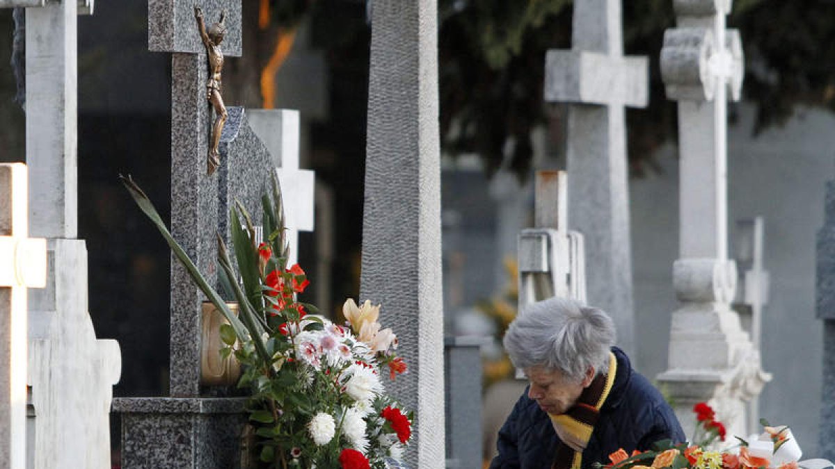 Una mujer arregla una sepultura en el cementerio de la capital leonesa, ayer en Puente Castro.
