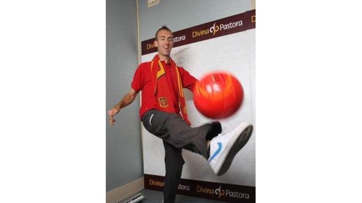 Sergio, con la camiseta de España, bromea con un balón.