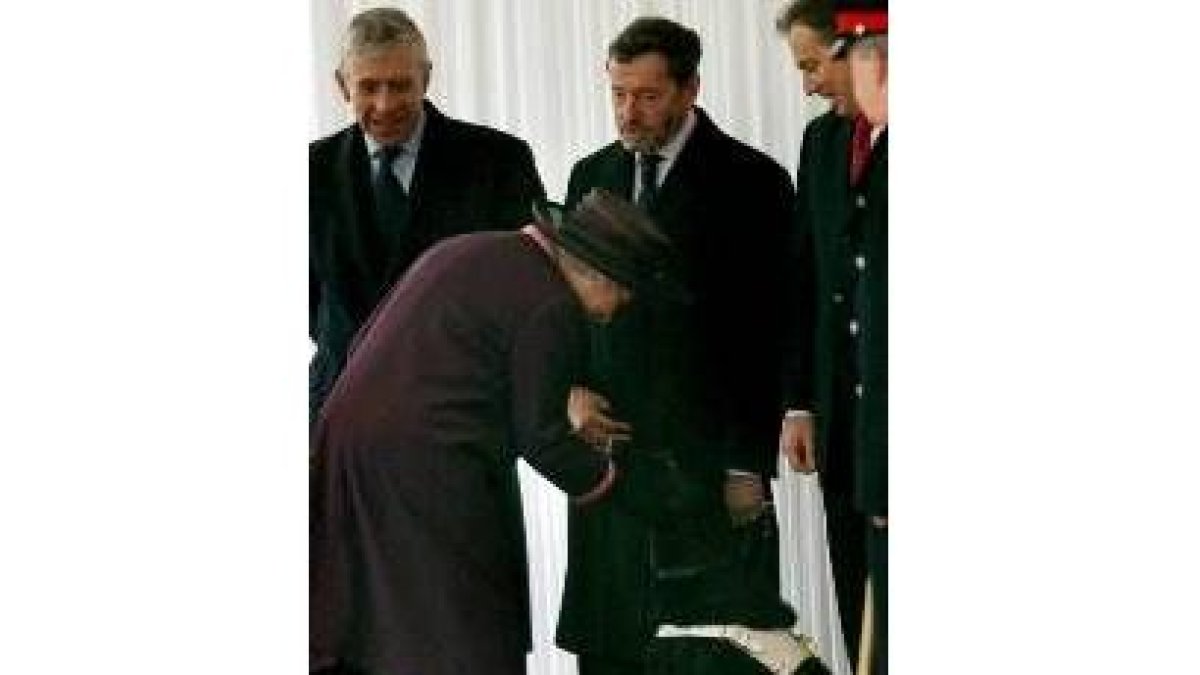 La reina Isabel hace un gesto cariñoso al perro guía de David Blunkett, en el centro