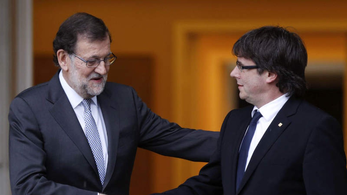 Rajoy saluda a Carles Puigdemont momentos antes de su primera reunión. PACO CAMPOS