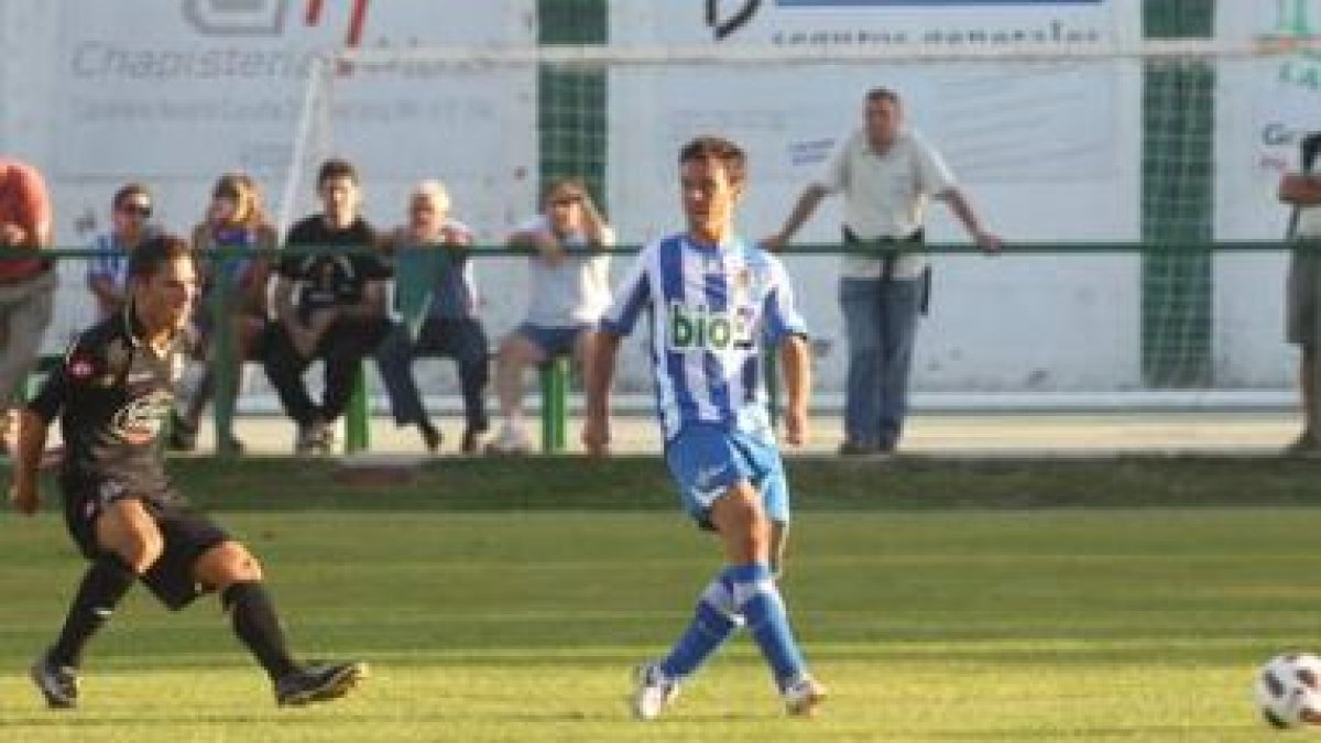 Pepe Alcaide, a la derecha, cede un balón hacia atrás ante la presencia del punta deportivista Dioni