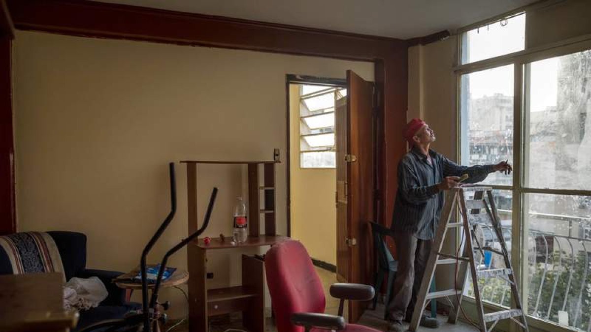 Un obrero realiza labores en un apartamento ocupado en Venezuela. M. GUTIÉRREZ