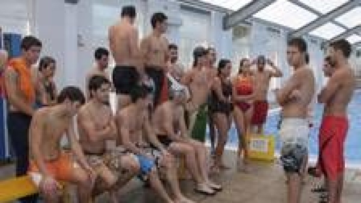 Los alumnos de salvamento escuchan las indicaciones de un monitor, en la piscina climatizada
