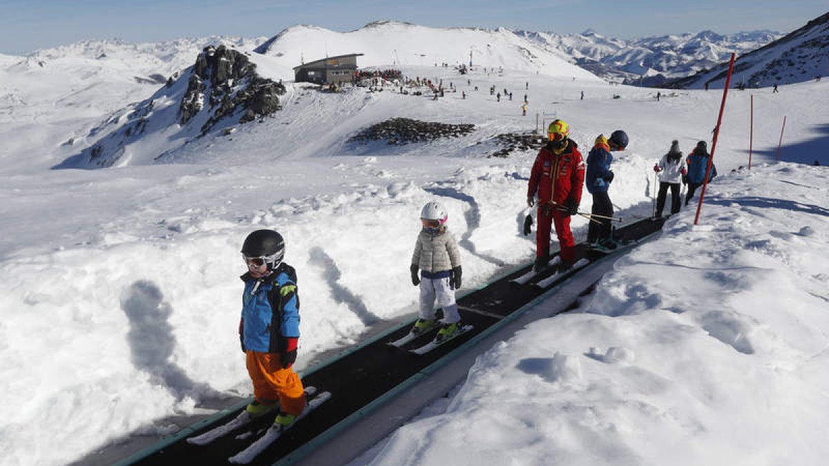 Futuros esquiadores en fila suben por la cinta transportadora para disfrutar de un gran día de nieve en San Isidro. JESÚS F. SALVADORES