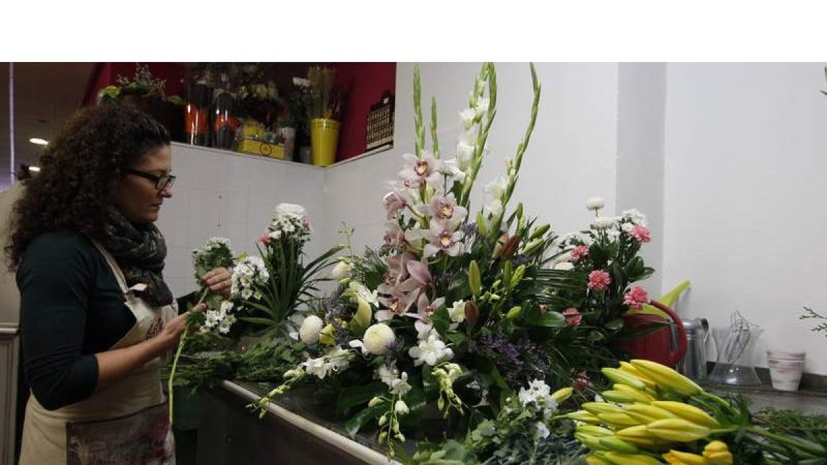 Una florista de León elabora un tradicional ramo de flores para recordar a los difuntos.