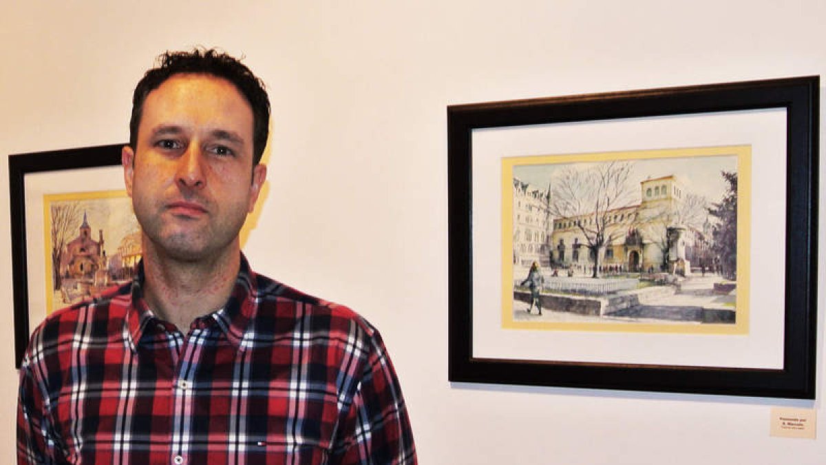 Juan Fernández ante dos de las obras que muestra en Villapérez.