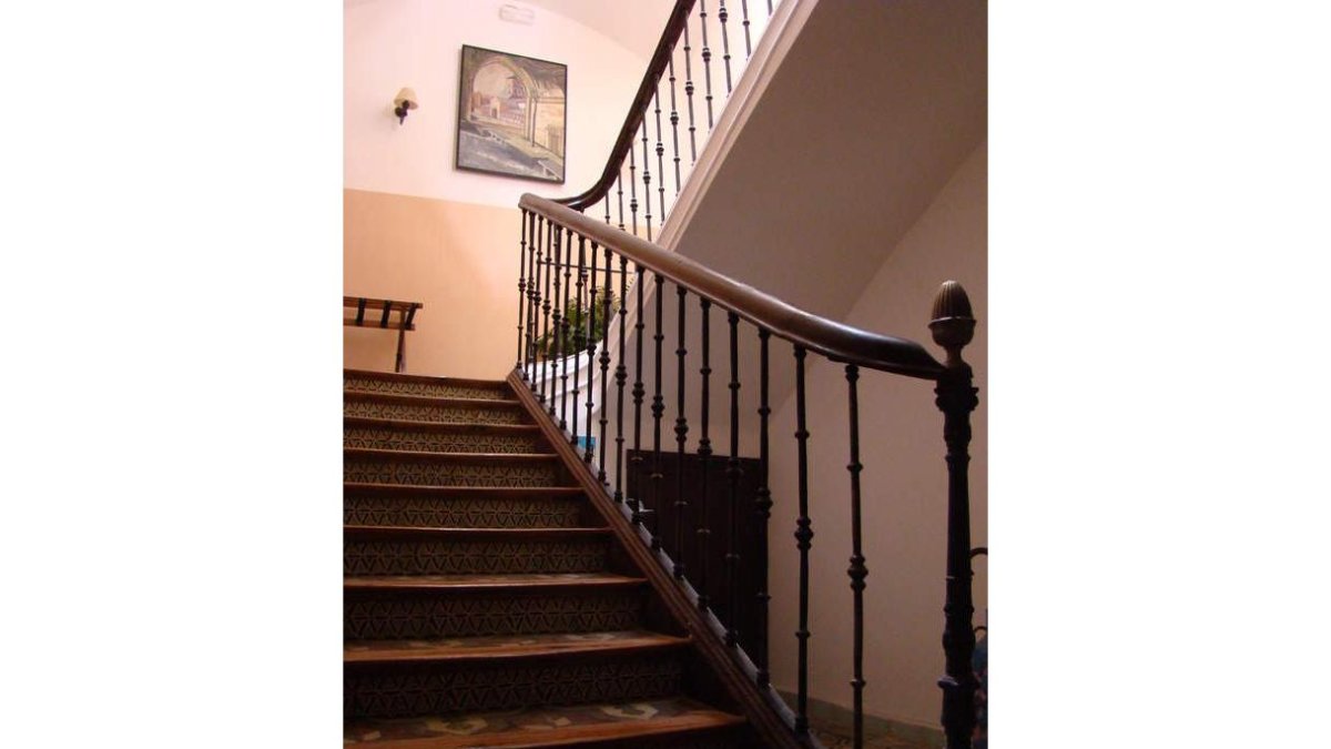 Escalera de madera y forja, uno de los dormitorios y saloncito del café deLos Balcones del Camino,en Sahagún.