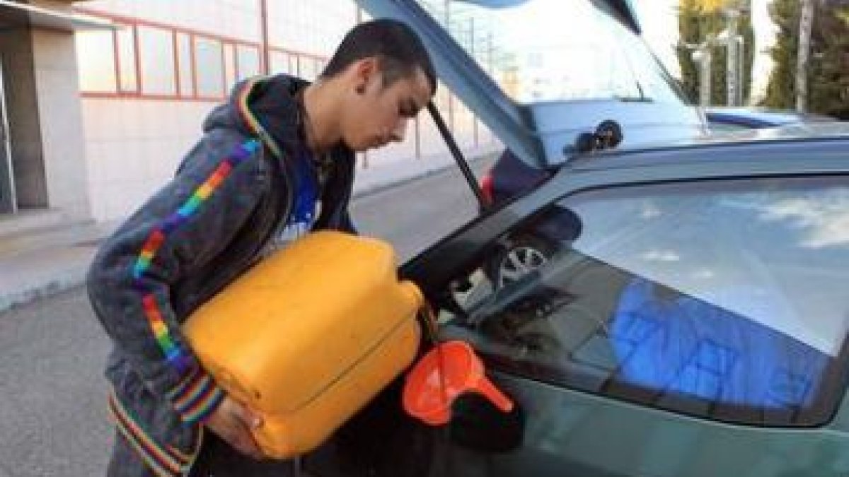 Omar, echando aceite de girasol a su vehículo para viajar desde Valladolid a Matadeón de los Oteros.