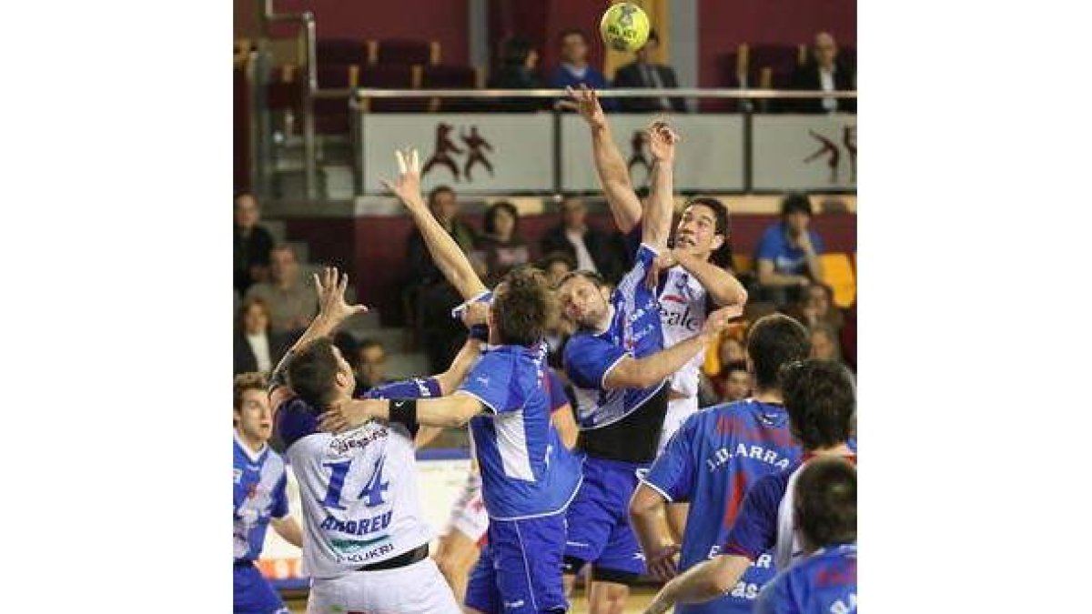 El lateral Iosu Goñi, intenta un pase al pivote Andreu totalmente rodeado por jugadores del Arrate.