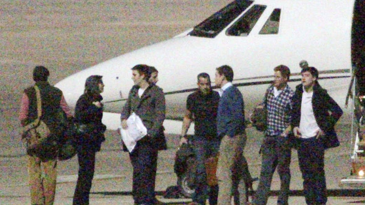 William, con jersey azul y Harry, con camisa a cuadros, en el aeropuerto.