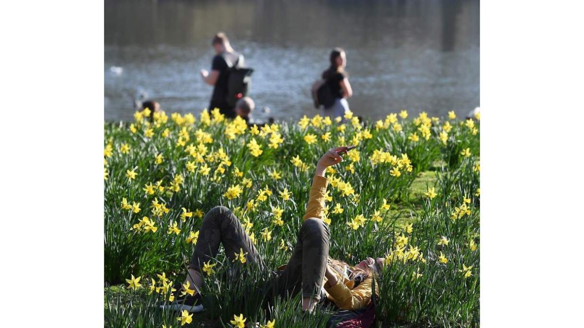 Jóvenes disfrutan del buen tiempo en el St. James’s Park de Londres. ANDY RAIN