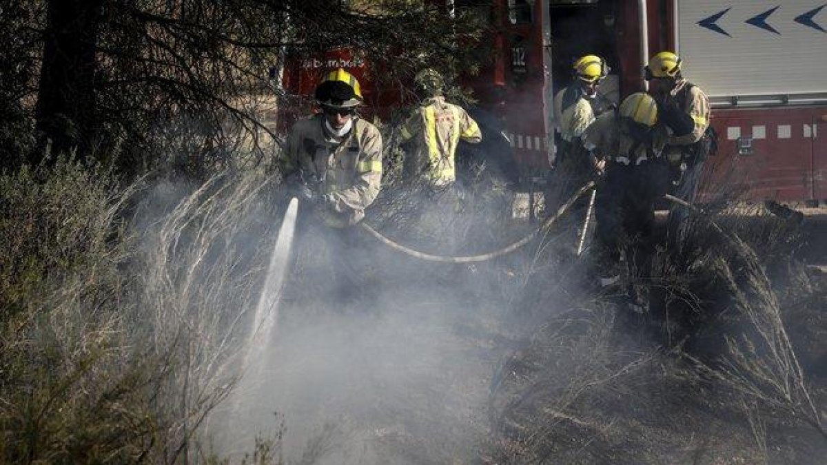 Bomberos en los trabajos de extinción del incendio de la Ribera dEbre.