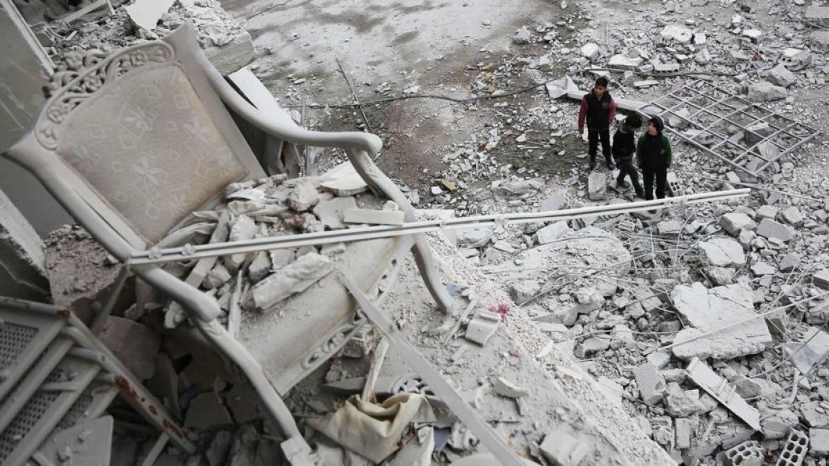Niños frente a la destrucción en la ciudad de Arbin, en el este de Siria.