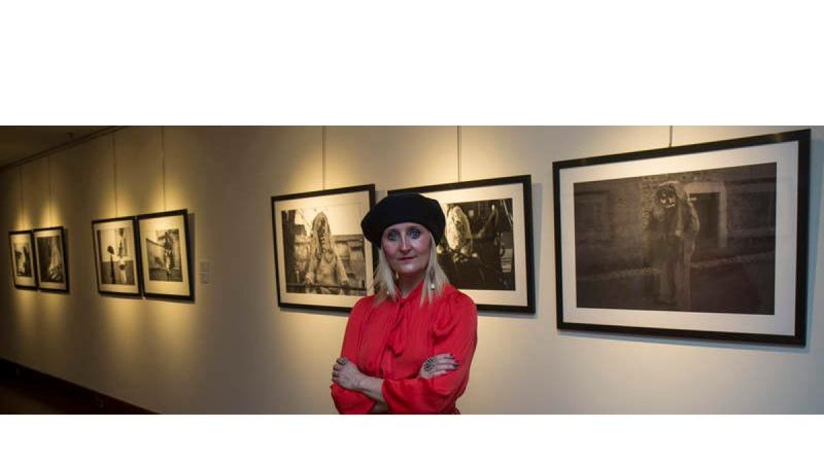 La fotógrafa leonesa Carmen Coque ante algunas de las fotografías de la serie dedicada al antruejo. FERNANDO OTERO