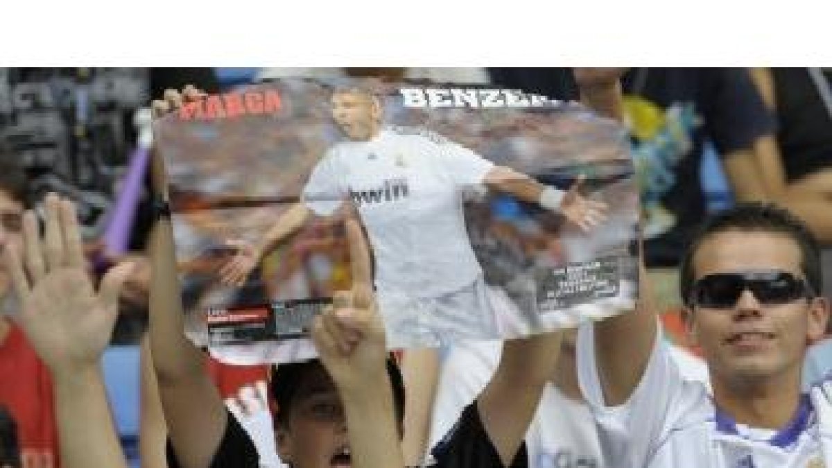Aficionados del Madrid con un póster de Benzema durante la presentación.