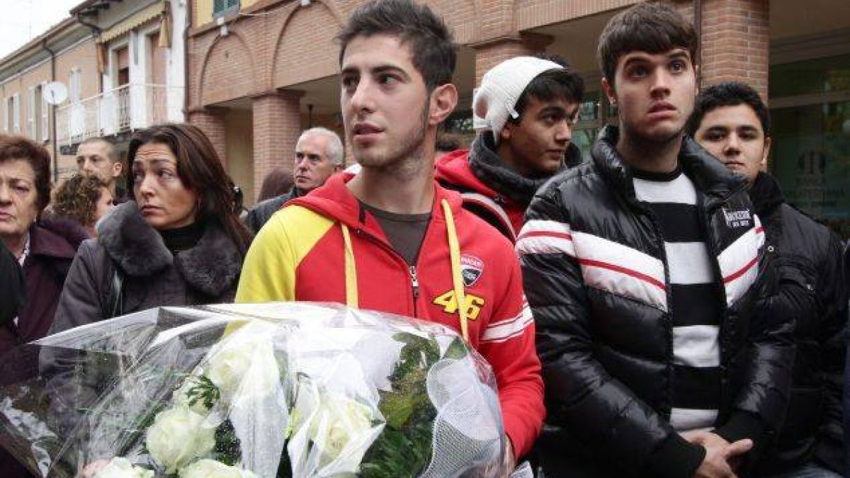 Varias personas esperan, a pesar de la lluvia, a las puertas de la capilla ardiente del piloto italiano de MotoGP Marco Simoncelli.