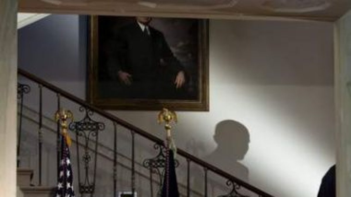 La sombra de Obama mientras se dirige hacia el gran vestíbulo de la Casa Blanca.