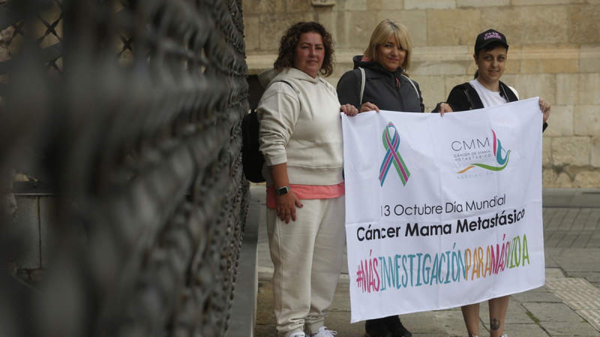 María Luisa, Luz Divina y Silvia Vega, ayer en Botines con el cartel del Día Mundial. FERNANDO OTERO