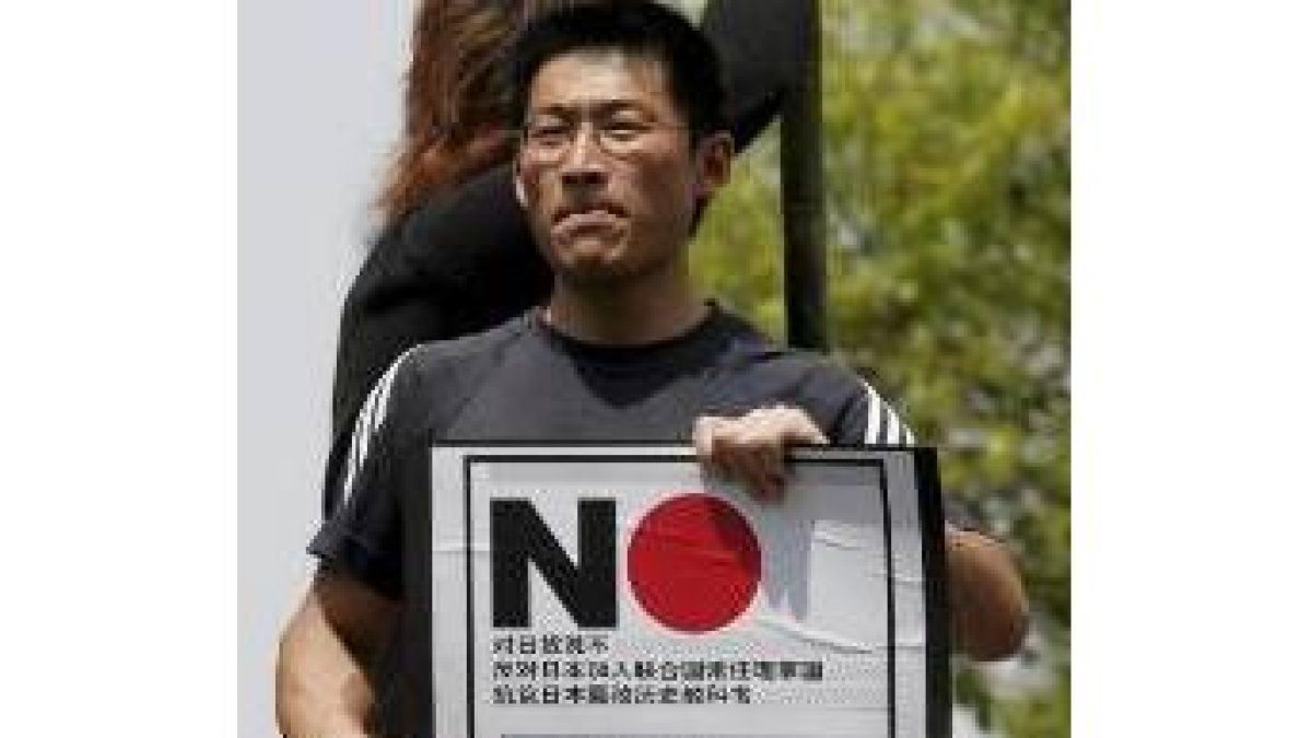 Un joven chino porta una pancarta en la que se pide el boicot a los productos japoneses