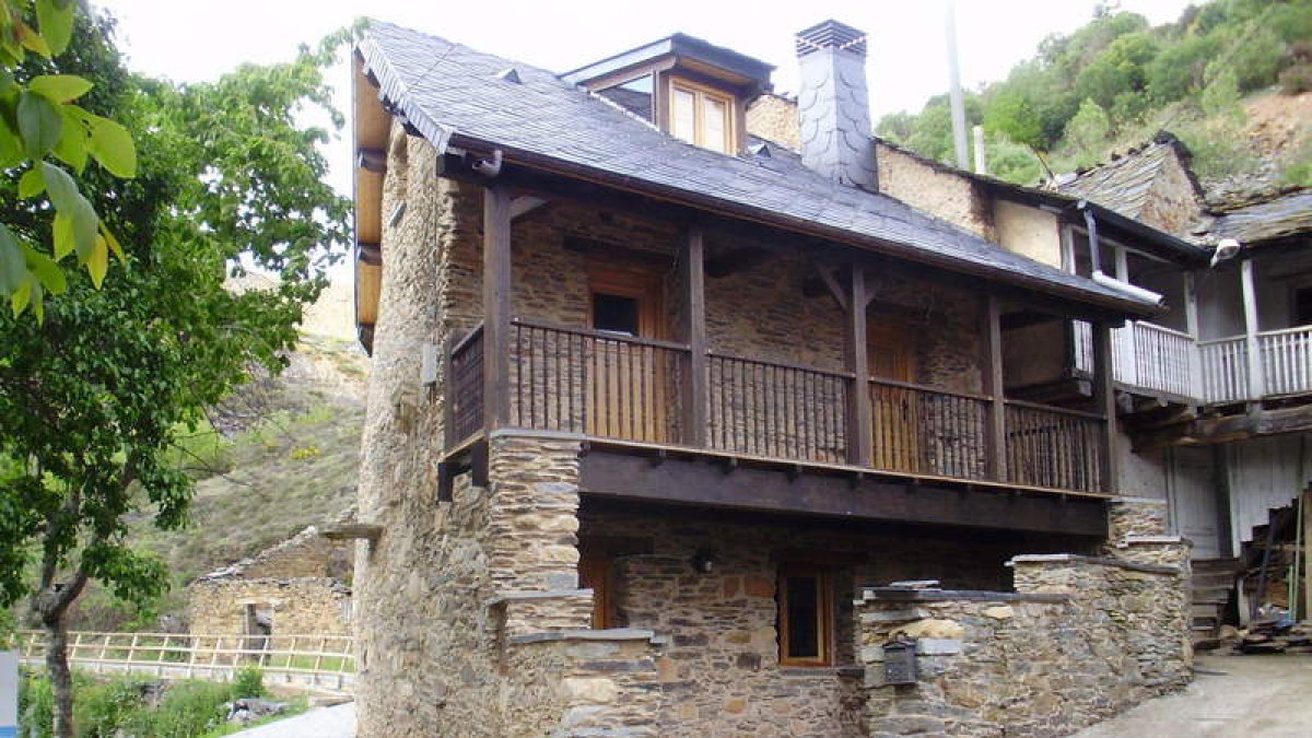 Exterior y salón de la Casa Rural Amelia, en el pueblo berciano de Anllares del Sil.