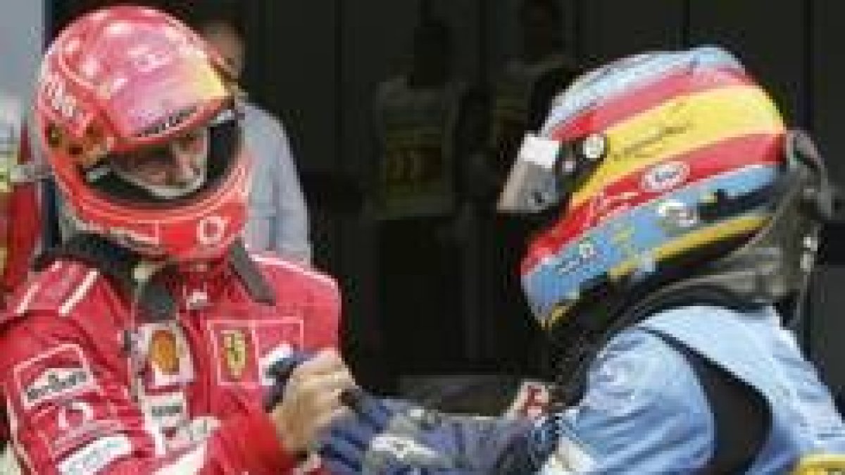 El piloto alemán Michael Schumacher saluda al español, líder del Mundial, Fernando Alonso
