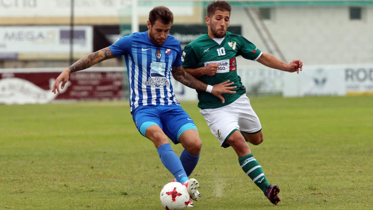 Álex Arias, a la derecha en una pugna con Jon García, fue el autor del único tanto del partido, que le dio los tres puntos en juego al Coruxo. MARTA G. BREA