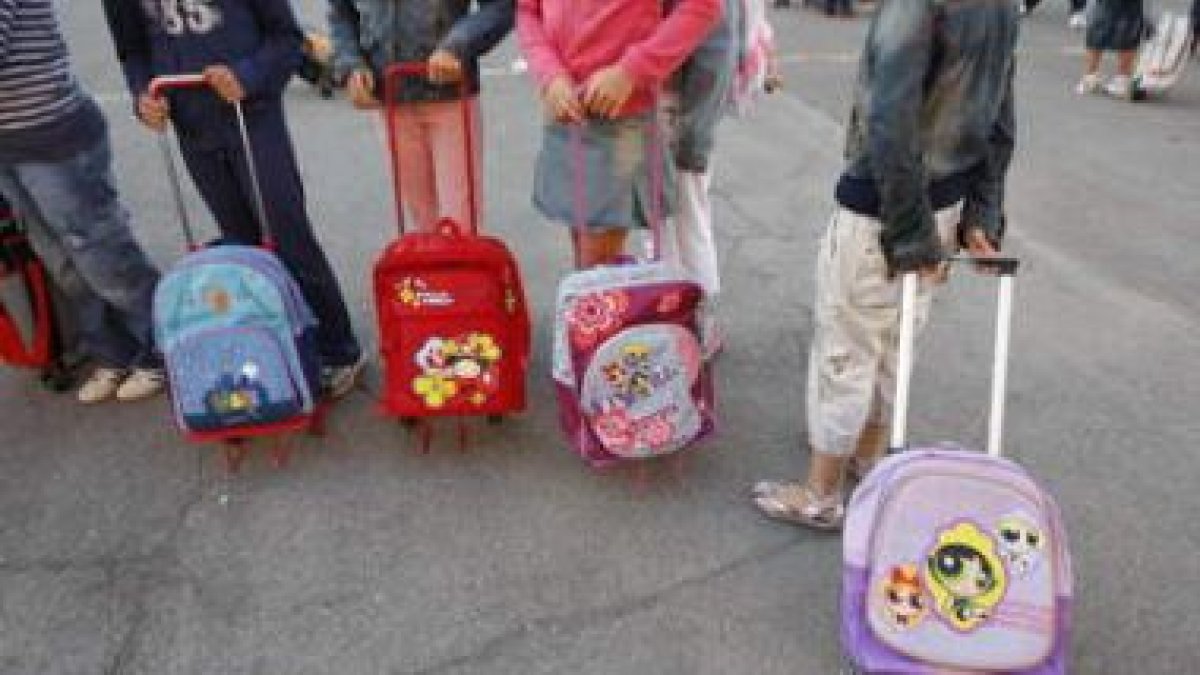 Un grupo de niños espera a la entrada de un colegio, en una imagen de archivo