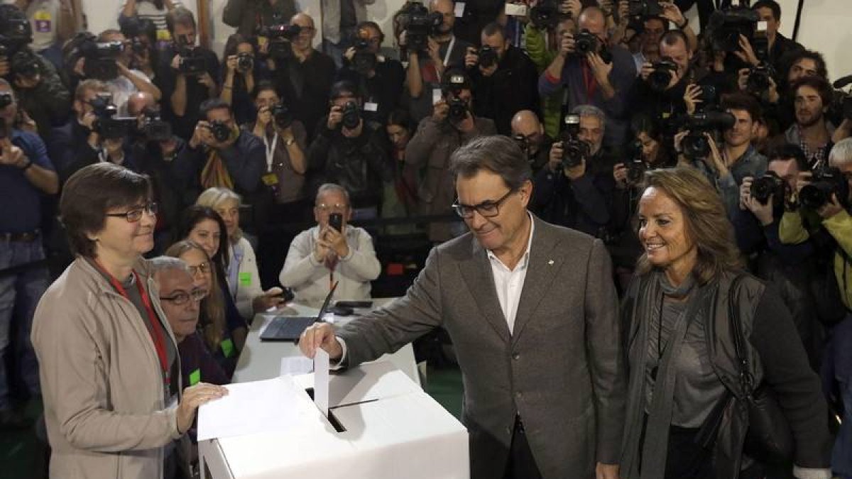 El presidente de la Generalitat, Artur Mas, acompañado de su esposa,Helena Rakosnik, en la Scola Pia de Balmes donde depositó su papeleta en la jornada participativa, sin carácter vinculante, convocada hoy para que los catalanes se pronuncien sobre la ind