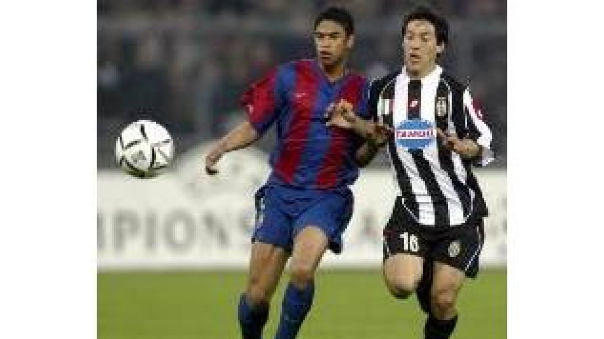 El holandés Reiziger pugna por el control del balón con el jugador juventino Camoranesi