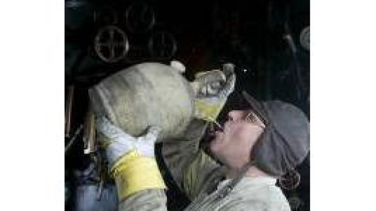 Un ferroviario bebe de un botijo durante un viaje en tren
